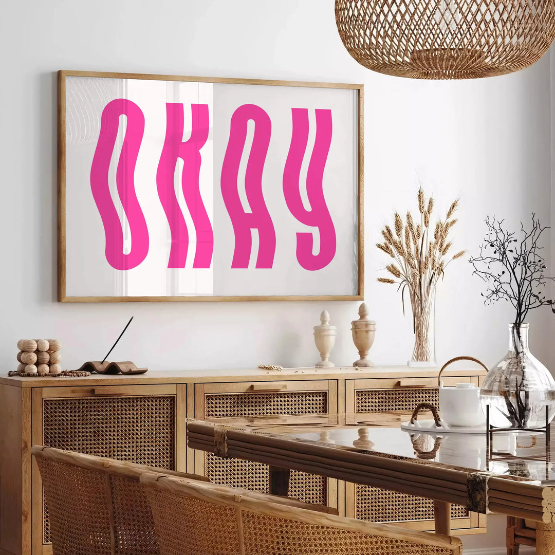 Motivational poster with the phrase 'Okay' in pink and white colors - in a Parisian living room with a sofa and a fig plant