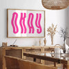 Motivational poster with the phrase 'Okay' in pink and white colors - in a Parisian living room with a sofa and a fig plant