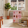 Graphic print of assorted fruits in bold black and brown tones - in a Parisian living room with a sofa and a fig plant