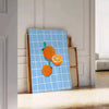 A bold orange kitchen poster featuring cooking utensils and ingredients in a modern style - leaning on a herringbone floor against a white panelled wall