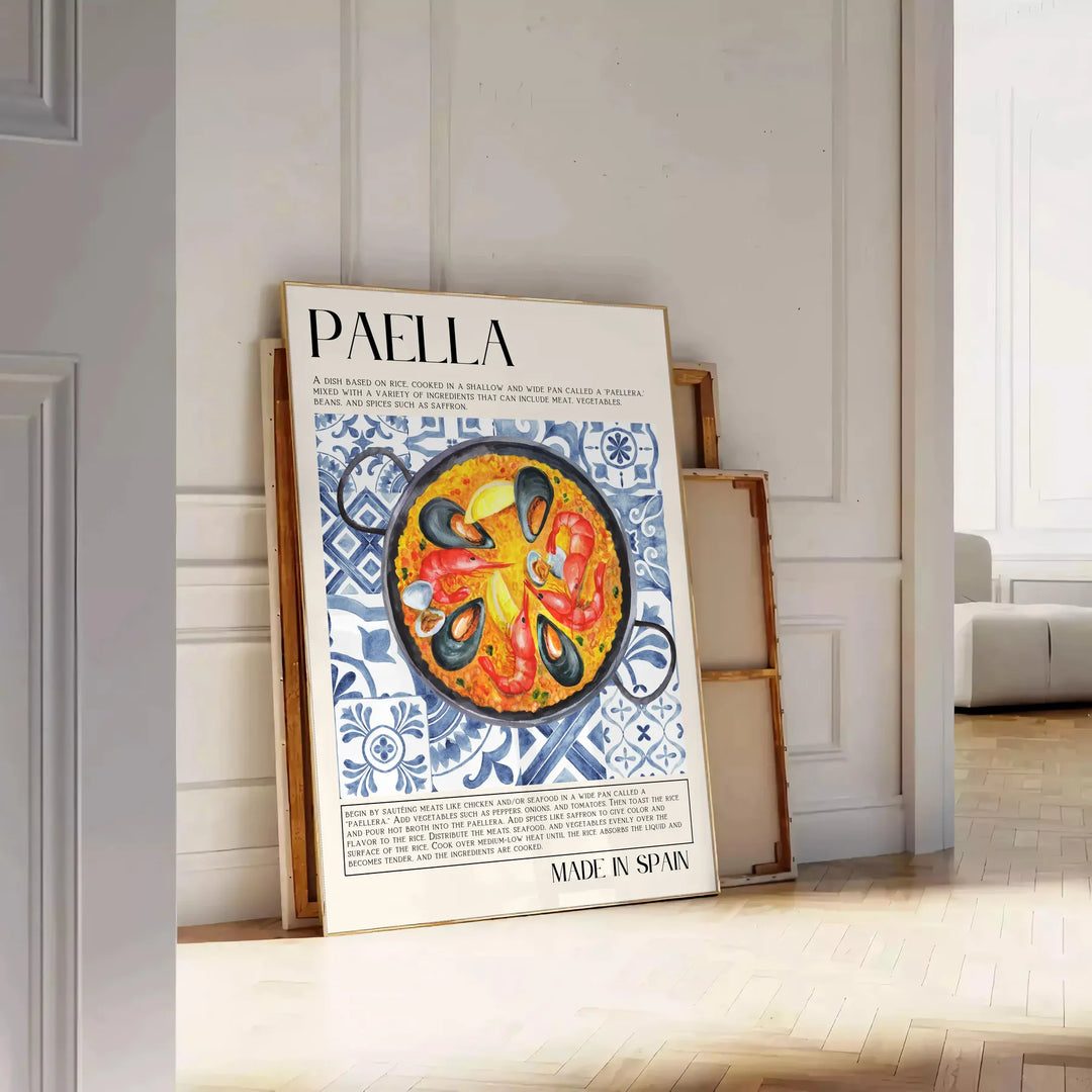 Eine farbenfrohe Darstellung eines Paella-Gerichts mit warmen Orange- und Weißtönen - an eine weiße Paneelwand gelehnt auf Fischgrätparkett