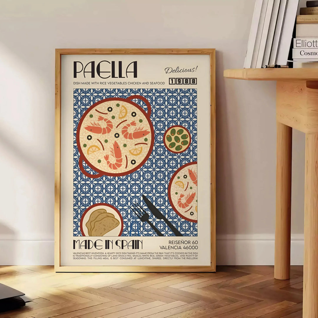 a colorful depiction of a paella dish with rich orange and gray tones - beside a round wooden side table with books