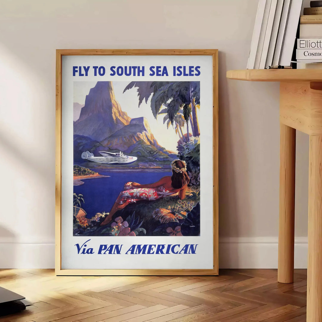 Vintage Pan American travel poster featuring a stylized airplane against a blue background - beside a round wooden side table with books