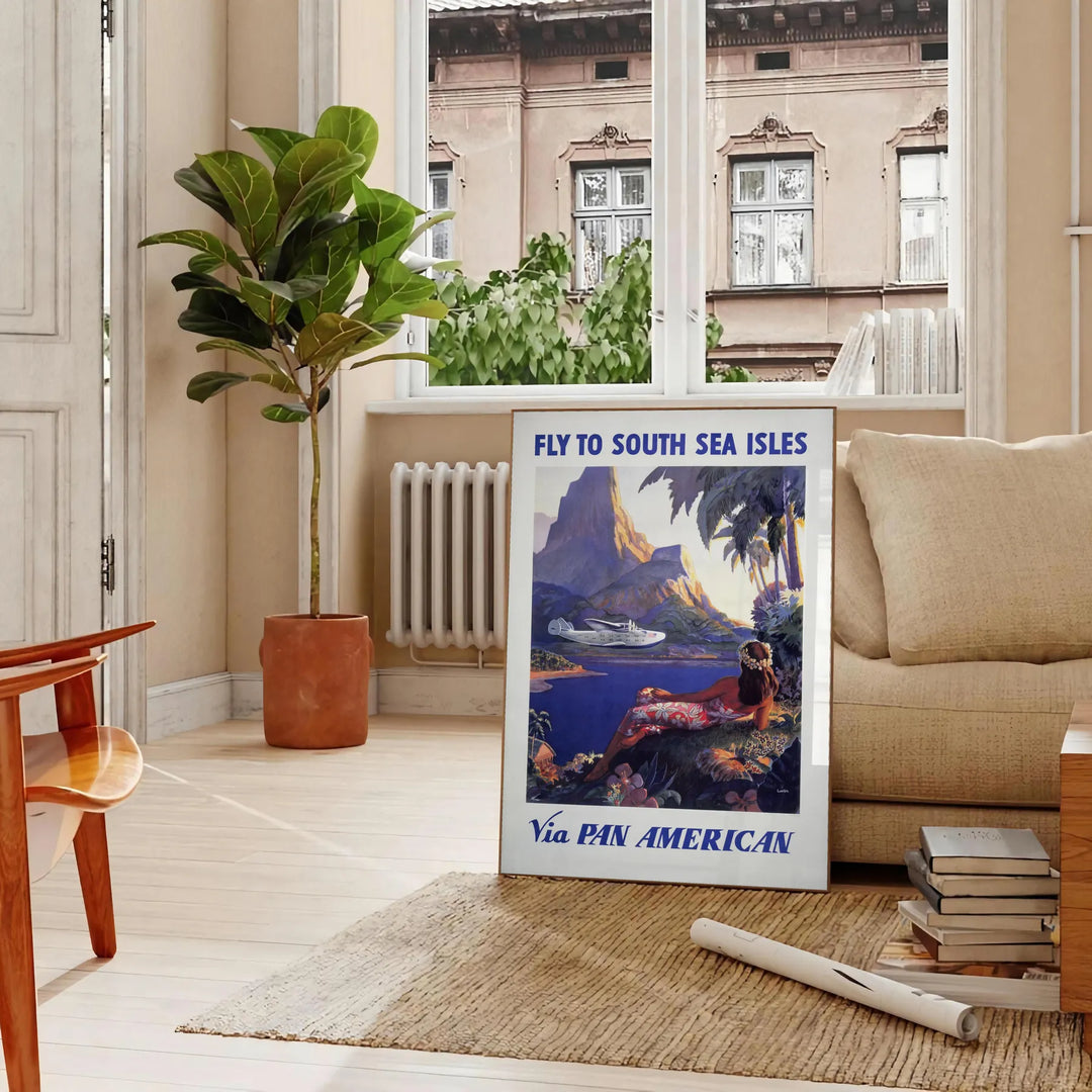 Vintage Pan American travel poster featuring a stylized airplane against a blue background - in a Parisian living room with a sofa and a fig plant