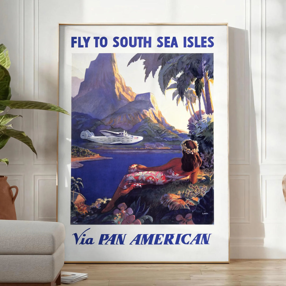 Vintage Pan American travel poster featuring a stylized airplane against a blue background - in a bright minimalist room with a plant and an armchair
