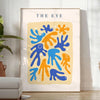 Poster de arte em papel recortado espaço em tons cinza e laranja - num quarto luminoso e minimalista com planta e poltrona