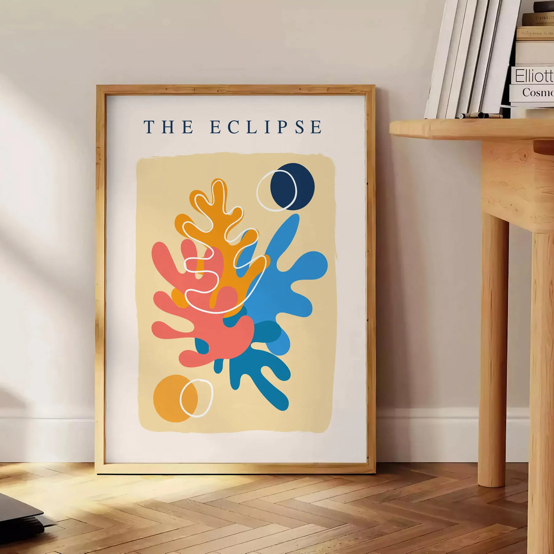 Layered paper cut design featuring abstract shapes in orange and blue - beside a round wooden side table with books