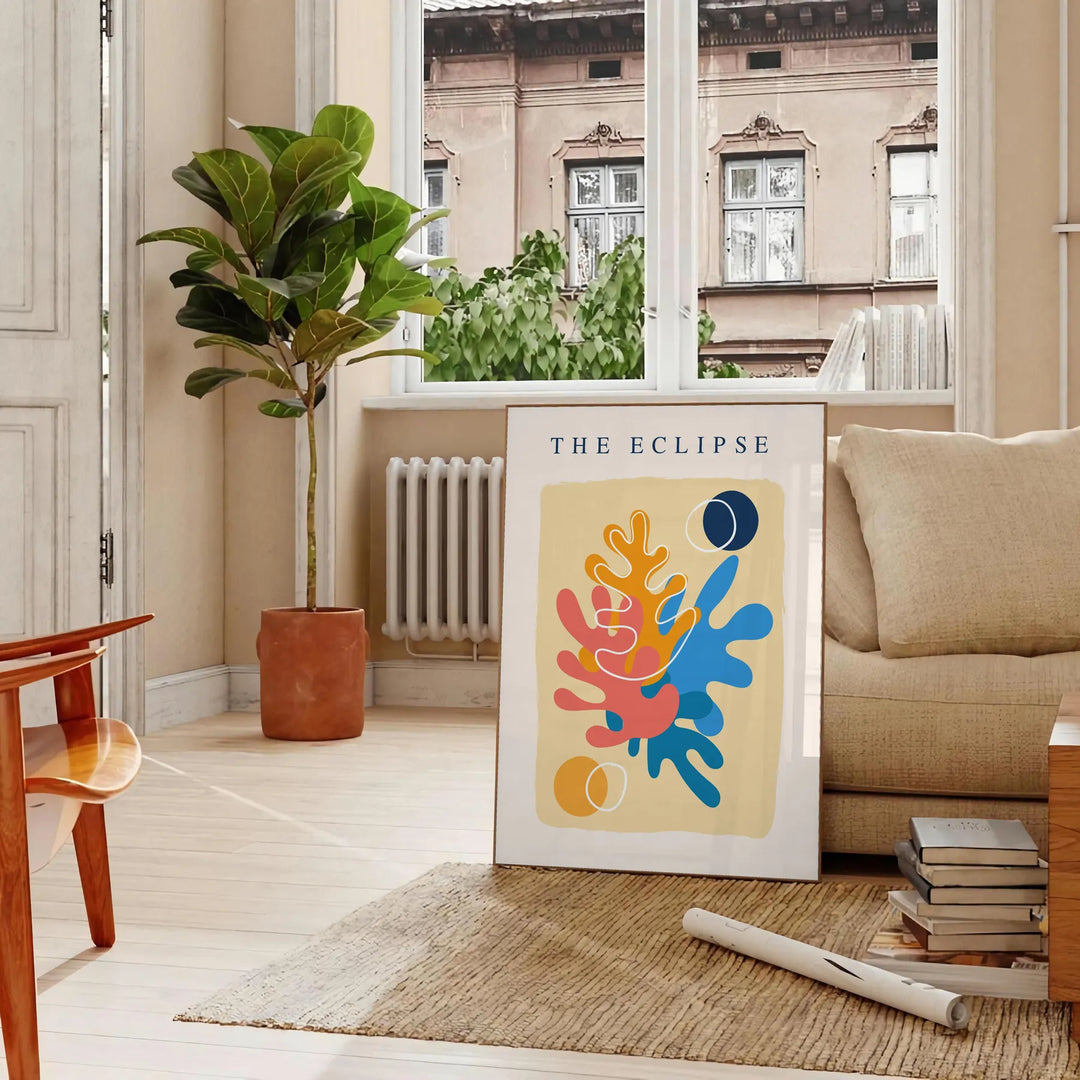 Layered paper cut design featuring abstract shapes in orange and blue - in a Parisian living room with a sofa and a fig plant