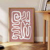 Minimalist paper-cut artwork in white and brown, layered abstract design - beside a round wooden side table with books