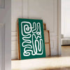 White and green paper-cut botanical artwork on minimalist poster - leaning on a herringbone floor against a white panelled wall