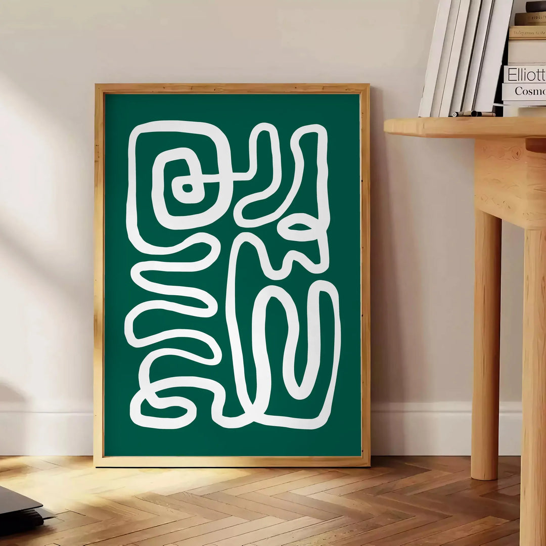 White and green paper-cut botanical artwork on minimalist poster - beside a round wooden side table with books