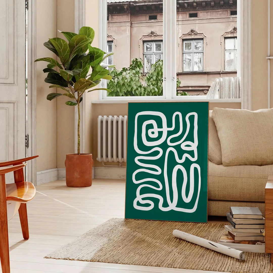 White and green paper-cut botanical artwork on minimalist poster - in a Parisian living room with a sofa and a fig plant