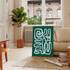 White and green paper-cut botanical artwork on minimalist poster - in a Parisian living room with a sofa and a fig plant