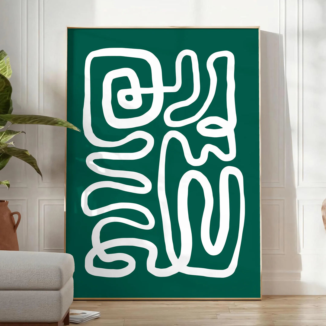 White and green paper-cut botanical artwork on minimalist poster - in a bright minimalist room with a plant and an armchair