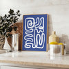 Gray and white space-themed poster featuring layered paper-cut artwork - styled on a counter with eucalyptus and a bowl of lemons