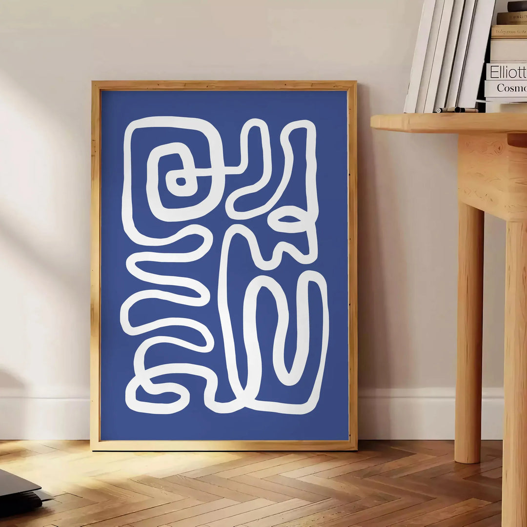 Gray and white space-themed poster featuring layered paper-cut artwork - beside a round wooden side table with books