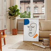 Paper-cut space collage poster in gray and white abstract design - in a Parisian living room with a sofa and a fig plant