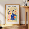 Abstract paper-cut design featuring layered orange and blue shapes - beside a round wooden side table with books