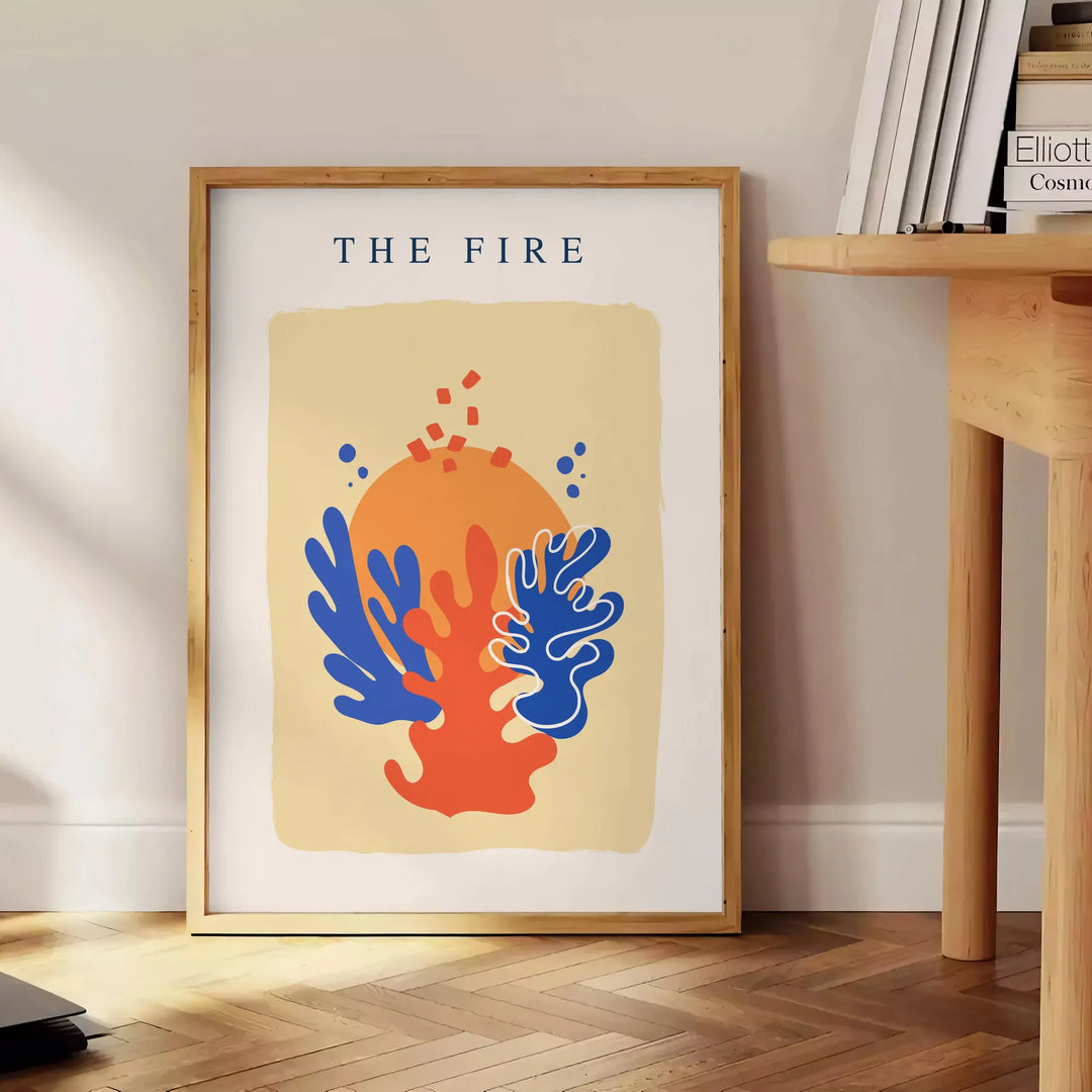 Abstract design featuring layered orange and blue paper-cut shapes - beside a round wooden side table with books