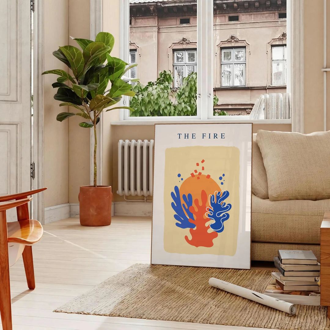 Abstract design featuring layered orange and blue paper-cut shapes - in a Parisian living room with a sofa and a fig plant