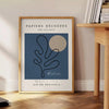 Póster gris y blanco estilo papel recortado abstracto minimalista - junto a una mesa auxiliar redonda de madera con libros