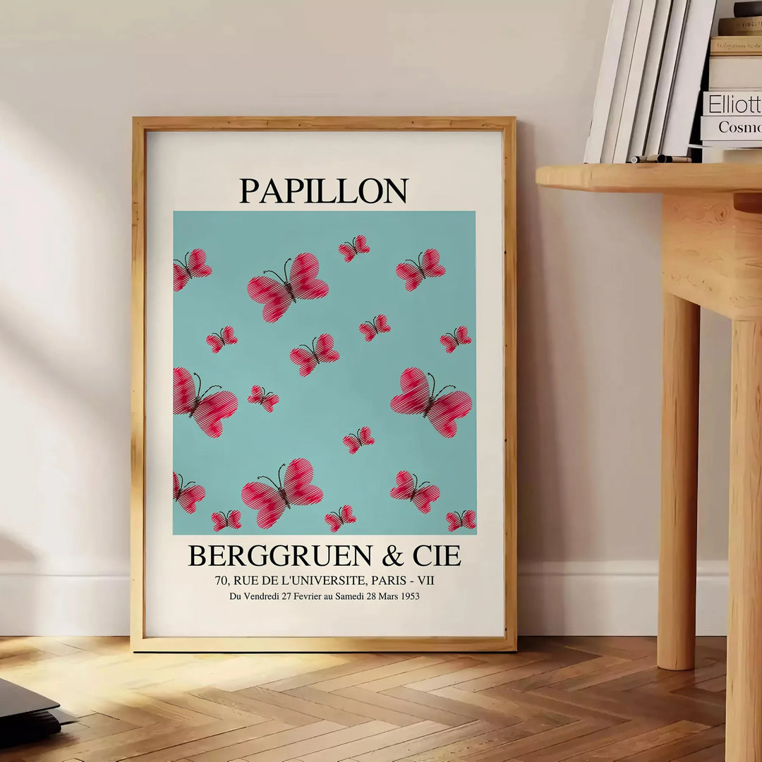 Maximalist poster featuring a colorful butterfly against a dark background - beside a round wooden side table with books