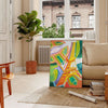 Graphic illustration of Paris with orange and blue tones - in a Parisian living room with a sofa and a fig plant