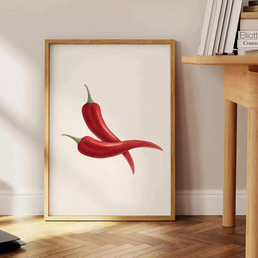 Una stampa moderna da cucina con peperoni rossi e grigi in un design stilizzato - accanto a un tavolino rotondo in legno con libri