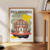 Illustration of Philadelphia skyline with green and brown tones - beside a round wooden side table with books