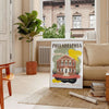 Illustration of Philadelphia skyline with green and brown tones - in a Parisian living room with a sofa and a fig plant
