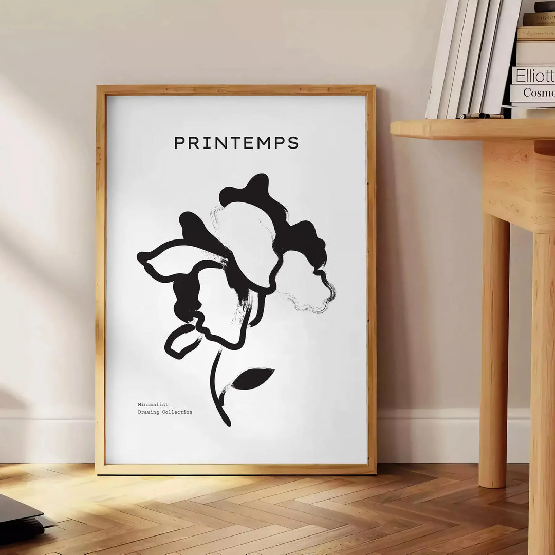 Botanical illustration featuring graceful plant designs in gray and black tones - beside a round wooden side table with books