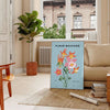 A lush green plant illustration with blue accents against a light background - in a Parisian living room with a sofa and a fig plant