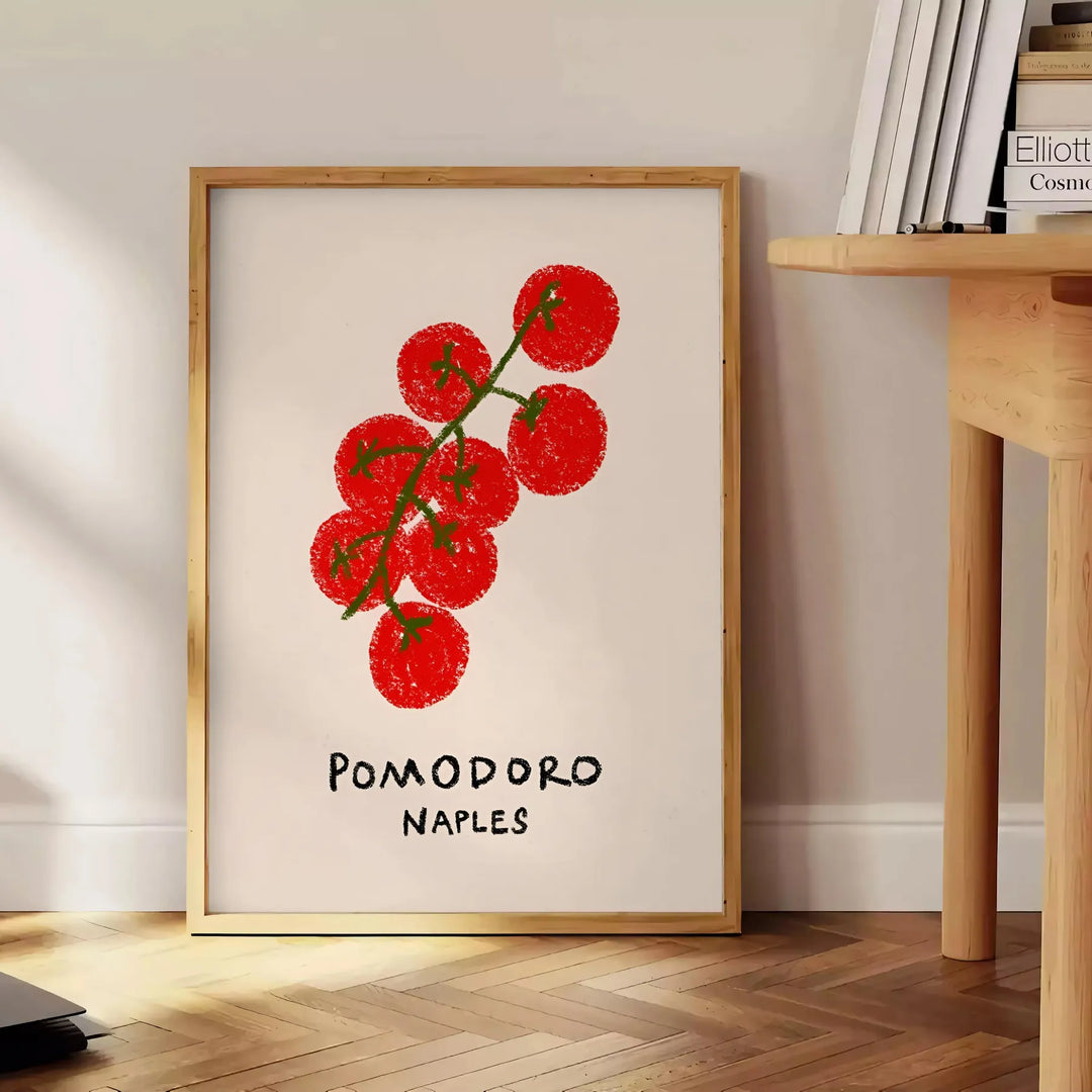 A colorful illustration of tomatoes and kitchen utensils inspired by Naples, Italy - beside a round wooden side table with books