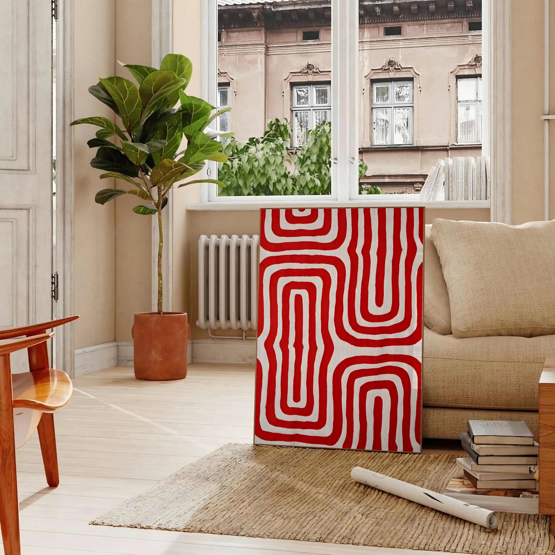 Abstract space scene with bold orange and red tones - in a Parisian living room with a sofa and a fig plant