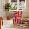 Abstract space scene with bold orange and red tones - in a Parisian living room with a sofa and a fig plant