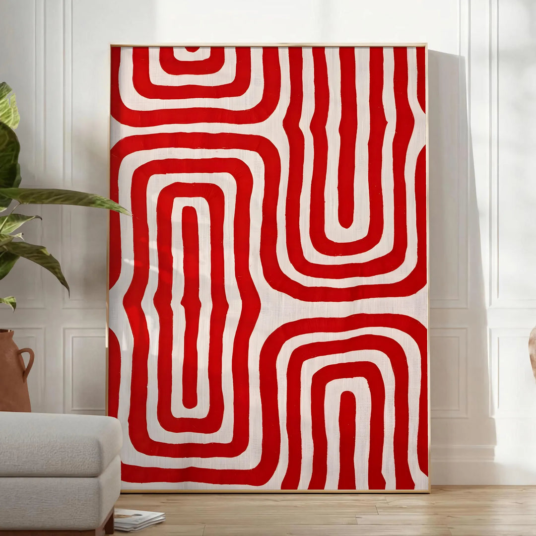 Abstract space scene with bold orange and red tones - in a bright minimalist room with a plant and an armchair