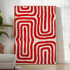 Abstract space scene with bold orange and red tones - in a bright minimalist room with a plant and an armchair