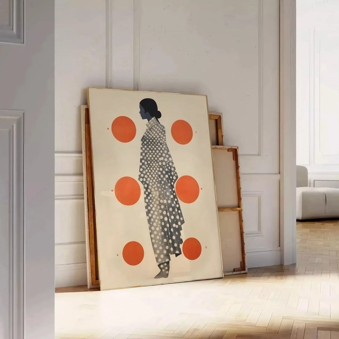 Stylish gray poster with vibrant orange abstract shapes - leaning on a herringbone floor against a white panelled wall
