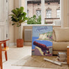 A travel poster featuring Puerto Rico's tropical landscape in earthy browns and greens - in a Parisian living room with a sofa and a fig plant