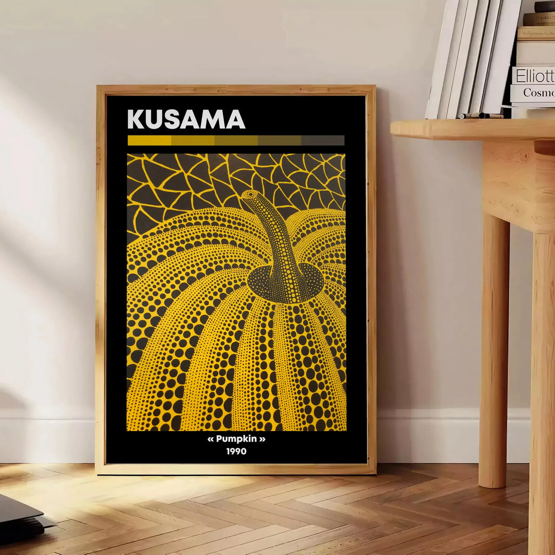 Dynia pokryta kropkami autorstwa Yayoi Kusama, w dominujących czerniach i pomarańczach - obok okrągłego drewnianego stolika z książkami