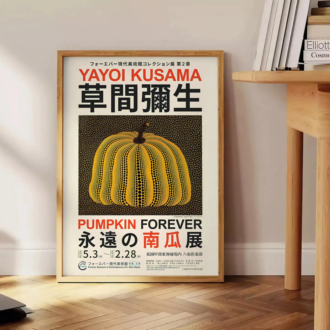 Yellow and orange pumpkin with polka dots by Yayoi Kusama - beside a round wooden side table with books