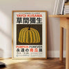 Yellow and orange pumpkin with polka dots by Yayoi Kusama - beside a round wooden side table with books