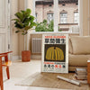 Yellow and orange pumpkin with polka dots by Yayoi Kusama - in a Parisian living room with a sofa and a fig plant