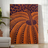 Yayoi Kusama pumpkin artwork with rich brown and green hues - in a bright minimalist room with a plant and an armchair