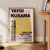 A pumpkin pattern in Yayoi Kusama's signature polka dot style with yellow and black colors - beside a round wooden side table with books