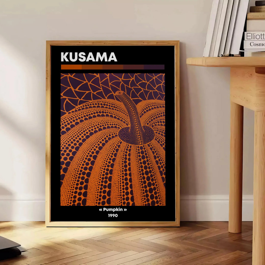 Orange pumpkin covered in black polka dots in Yayoi Kusama's style - beside a round wooden side table with books