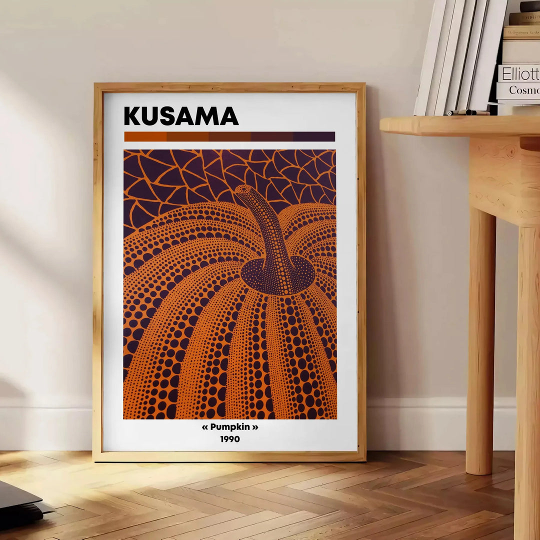 Fantazyjny wzór dyni w czerni i zieleni autorstwa Yayoi Kusama - obok okrągłego drewnianego stolika z książkami