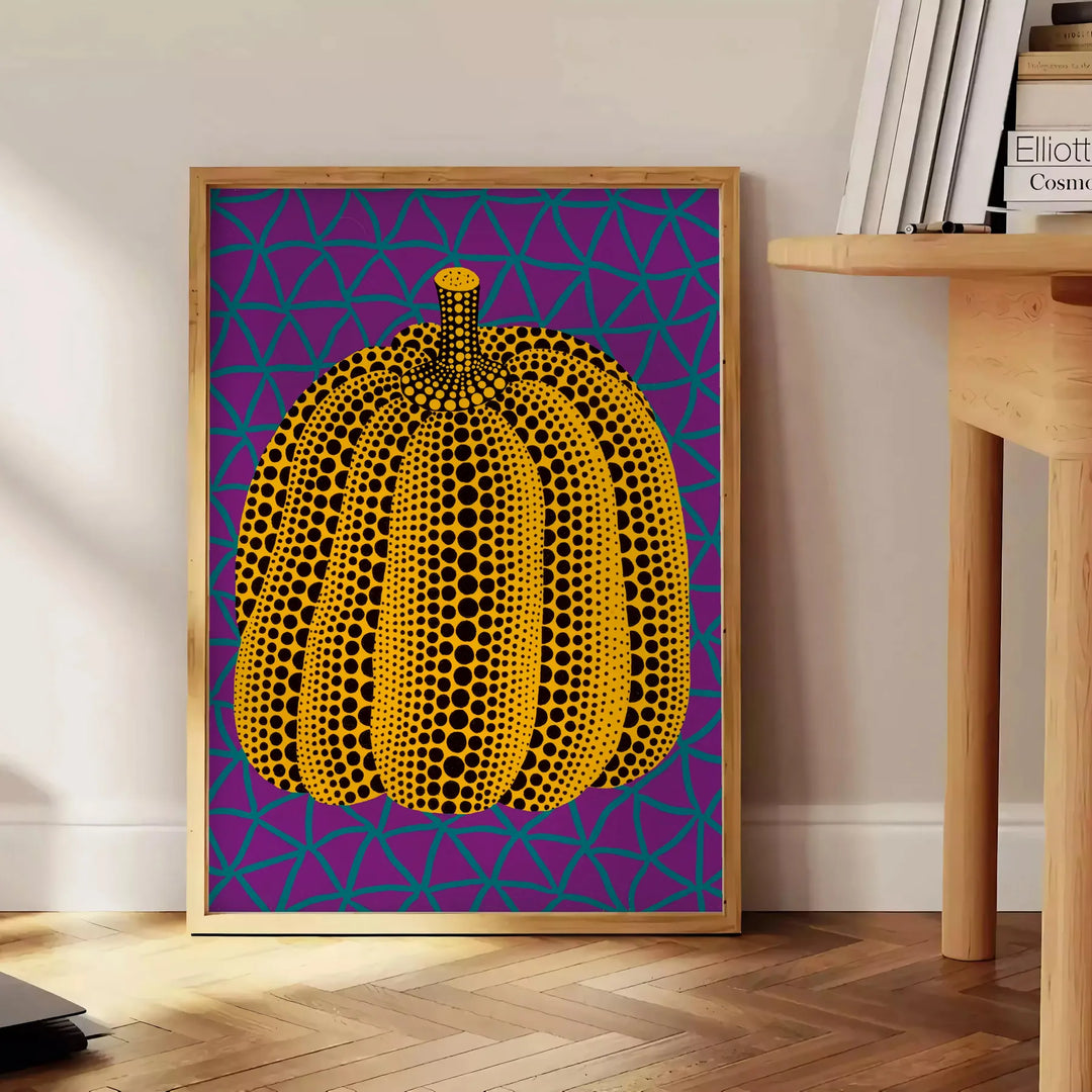 Colorful pumpkin pattern with polka dots by Yayoi Kusama - beside a round wooden side table with books
