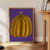 Colorful pumpkin pattern with polka dots by Yayoi Kusama - beside a round wooden side table with books