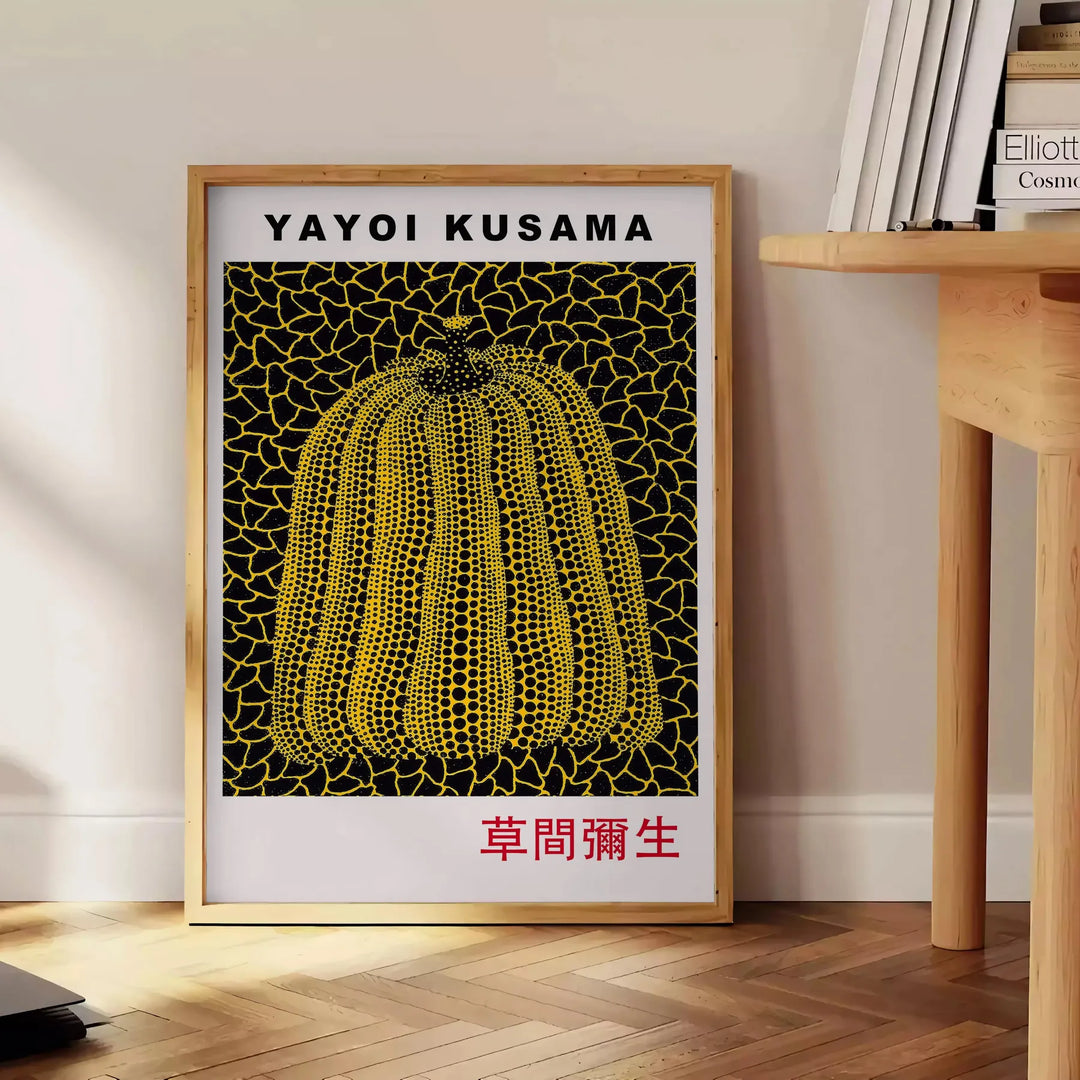 Yellow pumpkin with black polka dots in Yayoi Kusama's signature style - beside a round wooden side table with books